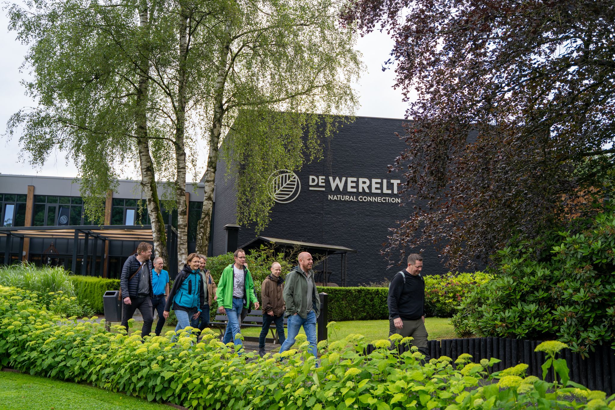 Congresbezoekers wandelen buiten tijdens een break bij De Werelt in Lunteren, midden in de natuur